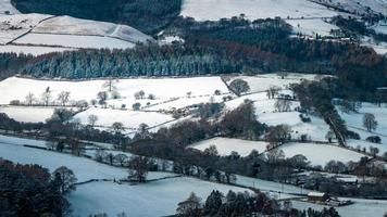 Vista aérea del paisaje invernal con campos, árboles y casas. foto