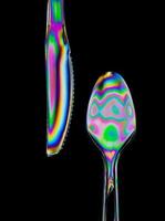 Image of photoelastic effect in knife and spoon with black background photo