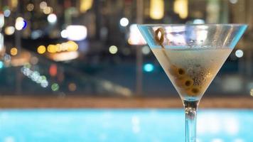 Cóctel en copa de martini con fondo de ciudad borrosa foto