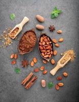 Cocoa powder and cacao beans on dark stone background photo