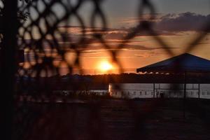 Sunset through a fence photo