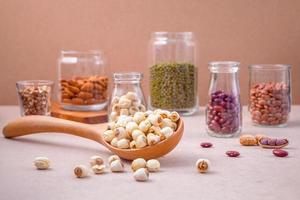 Beans and nuts in jars and a spoon photo