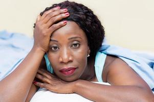 Portrait of a beautiful young black woman lying down photo