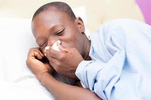 Young man with fever sick in bed photo