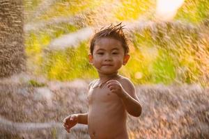 Asian boy playing with splashes of water