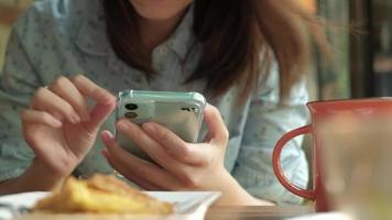 close-up van een vrouw met behulp van een smartphone in een café video