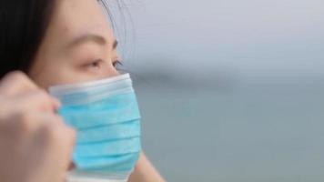 primer plano mujer asiática con una mascarilla. video