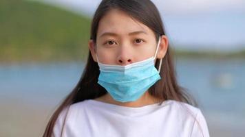 Asian women show how to put on protective face mask on face correctly. wrong way of using a medical face mask. video