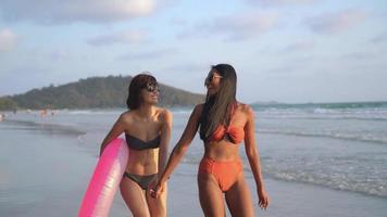 två kvinnor ler gå och ha kul på stranden video
