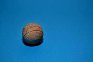 Small wooden ball on blue color background photo