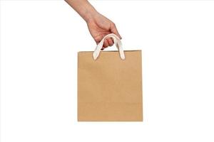 Maqueta de una mano sosteniendo una bolsa de papel artesanal reciclado aislado sobre un fondo blanco.