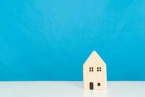 A wooden house on a blue background, loans market concept
