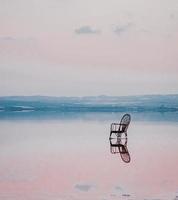 A chair in the middle of a salt lake photo