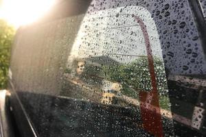 gotas de agua en el cristal del coche con luz suave foto