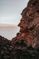 Brown rock formation near body of water during daytime photo