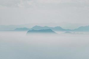 montaña de niebla bajo el cielo gris foto