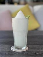 Lime smoothie in a glass on gray table photo