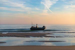 Polonia 2018- el hombre viaja por mar en bote inflable durante el amanecer foto