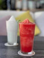 Watermelon smoothie in glass on gray table photo