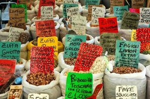 Frijoles surtidos en sacos blancos en el mercado italiano al aire libre foto