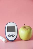 Herramientas de medición para diabéticos con manzana en la mesa foto