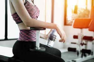 Fitness mujer en entrenamiento con fuertes abdominales mostrando en el gimnasio foto