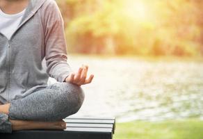 Joven mujer de yoga meditando, relajándose en la naturaleza foto