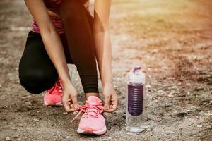 Young fit woman preparing for fitness running in the park photo