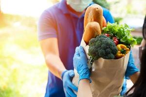 proveedores de servicios de alimentos con máscaras y guantes. quedarse en casa reduce la propagación del virus covid-19 foto