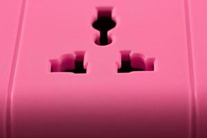 Close up picture of a pink outlet isolated on black photo