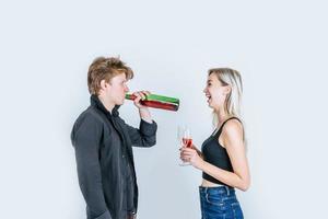 Portrait of happy young couple drinking wine in studio