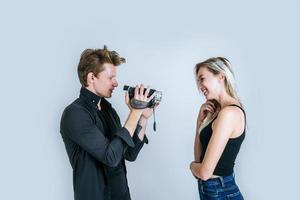 Happy portrait of couple holding video camera and recording a video