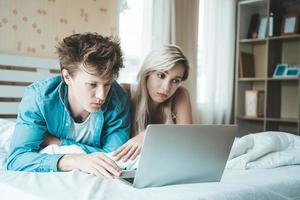 Happy couple Using laptop computer on the bed photo