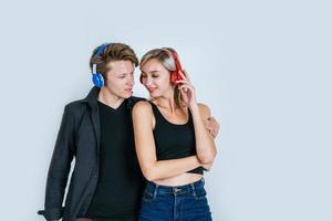 Feliz pareja joven en auriculares escuchando música en el estudio