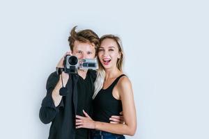 feliz retrato de pareja sosteniendo una cámara de video y grabando un video foto