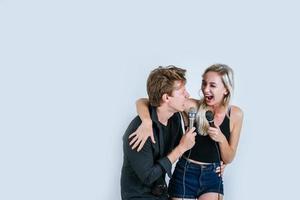 Happy portrait of couple holding microphones and singing photo