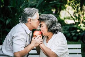 Elderly couple playing and eating some fruit photo