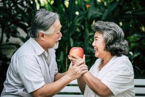 Elderly couple playing and eating some fruit photo