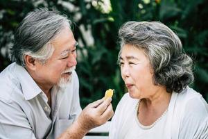 pareja de ancianos jugando y comiendo fruta foto