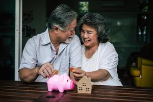 Elderly couple talking about finances with piggy bank photo