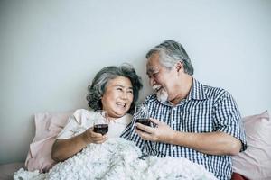 Elderly couple enjoying their anniversary in bedroom photo
