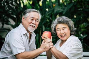 pareja de ancianos jugando y comiendo fruta foto