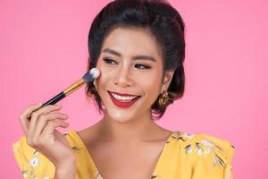 Portrait of a woman with makeup brush photo