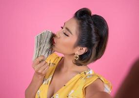 Happy fashionable woman holding money for shopping photo