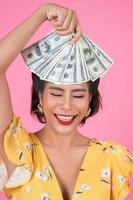 Happy fashionable woman holding money for shopping photo