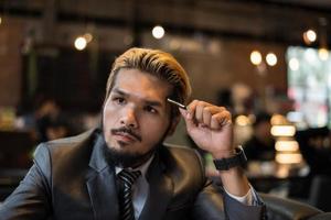 Handsome businessman thinking about work while working at cafe photo