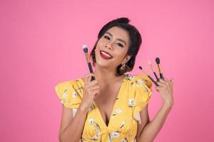 Portrait of a woman with makeup brushes photo