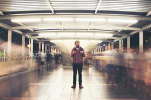 Handsome bearded man with backpack standing on the street traveling at night photo