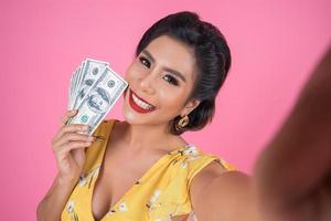 Happy fashionable woman holding money photo