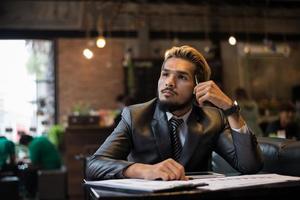 Handsome businessman thinking about work while working at cafe photo